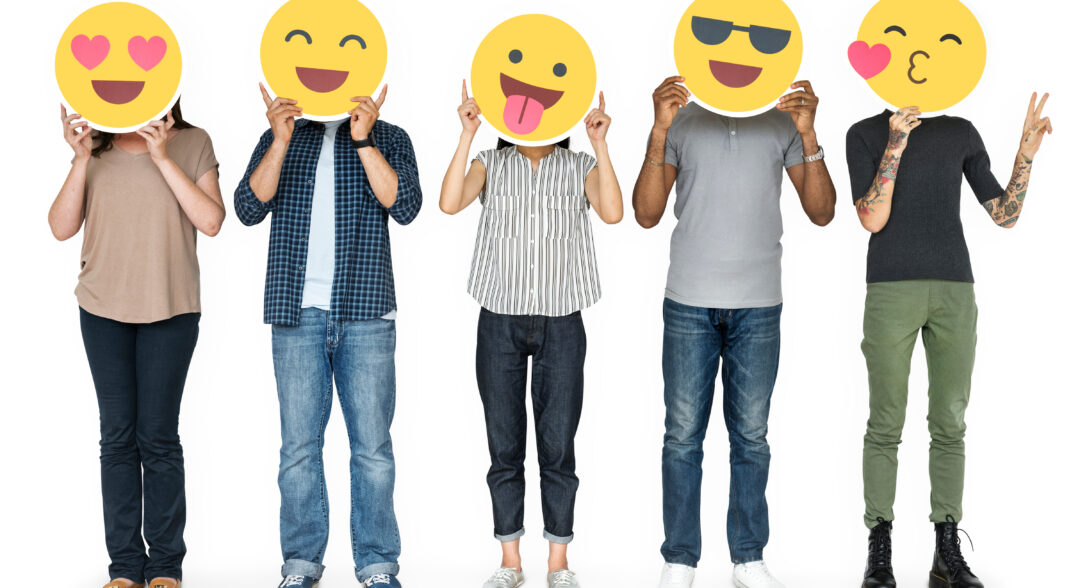 Férfiak és nők arcuk elé tartott emotikonokkal