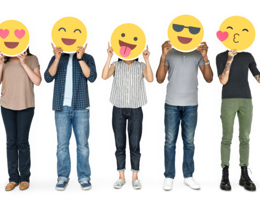 Férfiak és nők arcuk elé tartott emotikonokkal
