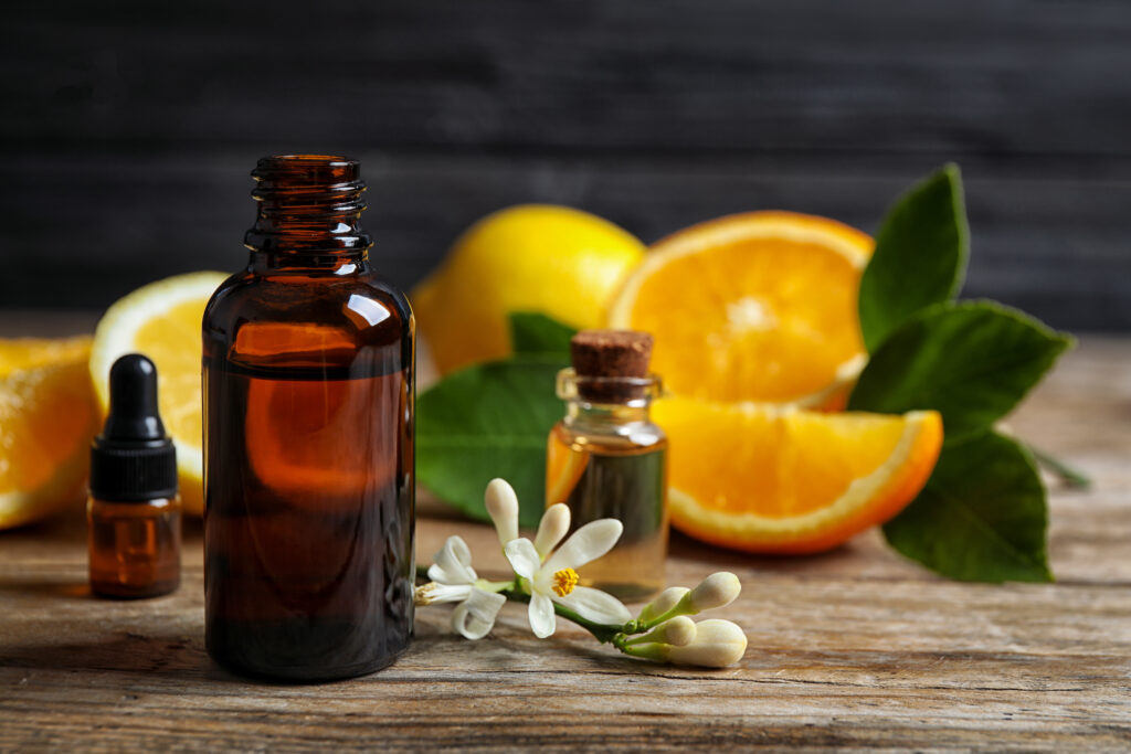 Citrusillóolaj faasztalon, háttérben citrusgyümölcsök.
