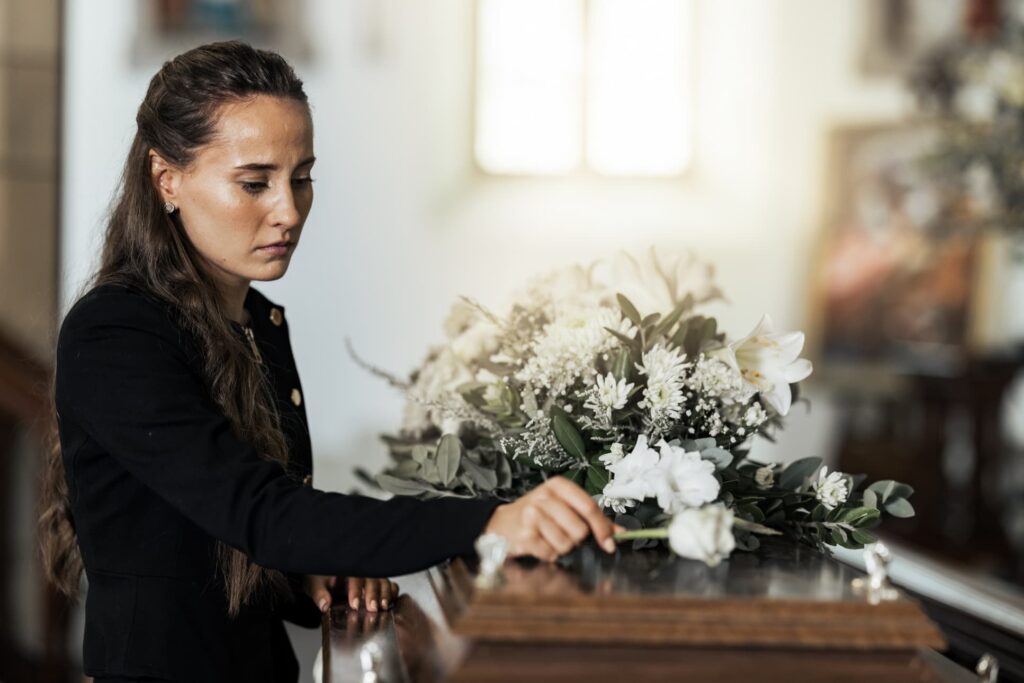 temetésen virágot hozó nő