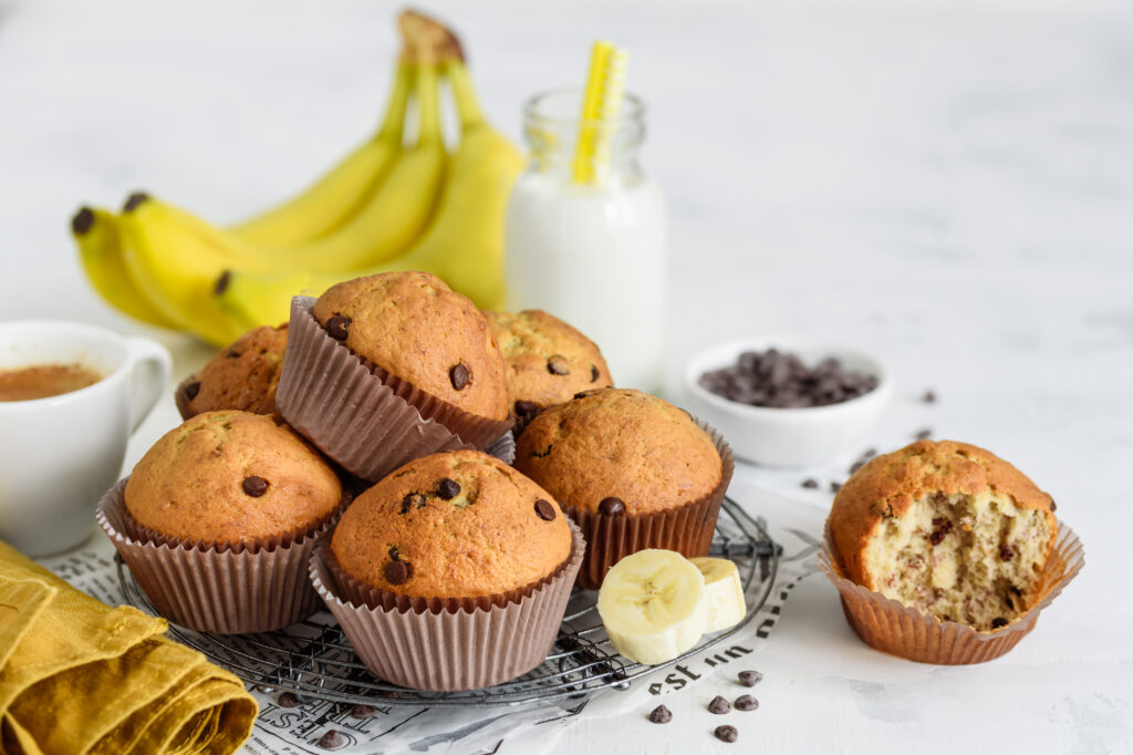 Csokis-banános muffinok fémállványon, fehér alapon.