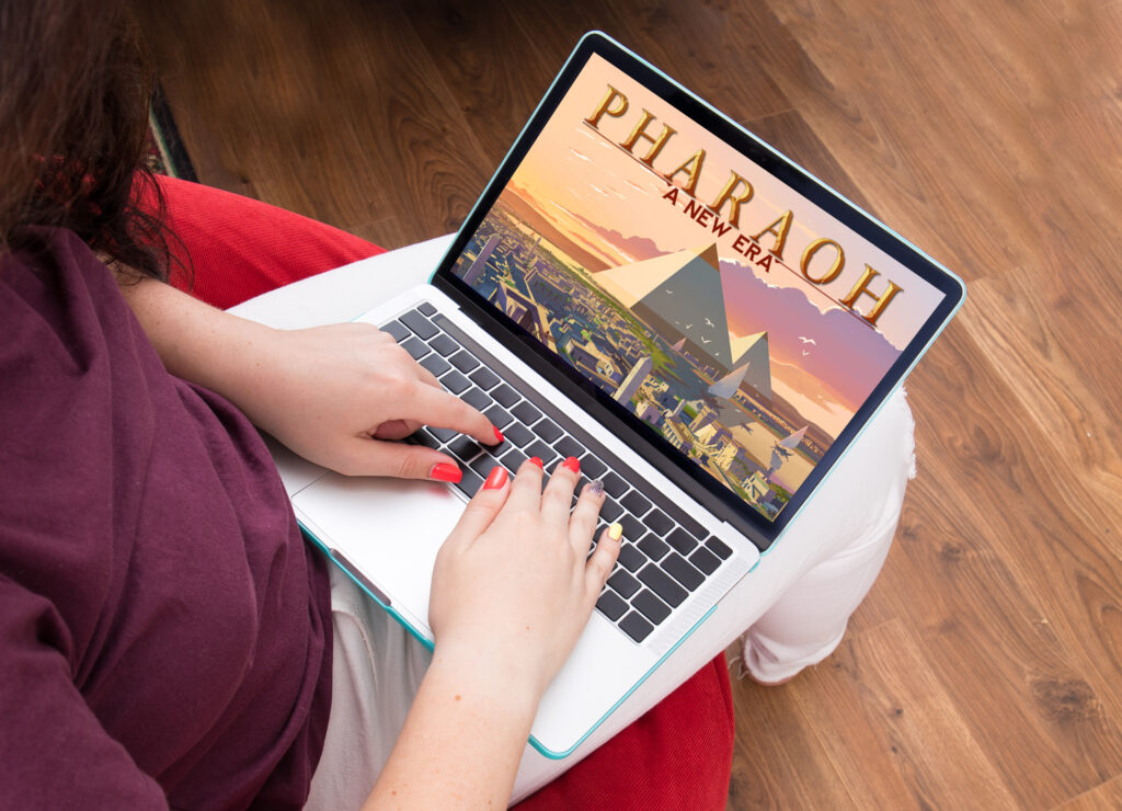 Lány játszik a Pharaoh: A New Era játékot laptopon