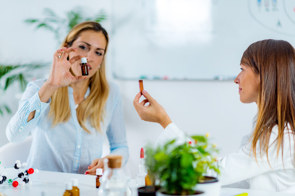 Orvosi konzultáción a páciens. Két nő homeopátiás üvegcsét tart a kezében.
