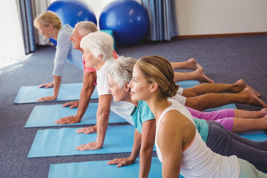 Pilatesz gyakorlatokat végeznek nők a földön.
