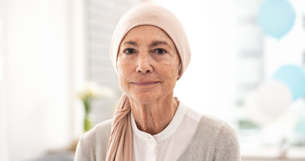 Arc, idős nő és rákos beteg a kórházban egészségügyi ellátás, wellness és gyógyulás céljából. Portré, idős és beteg személy a klinikán, erős gondolkodásmóddal, hogy bátorsággal küzdjön az egészségéért nyugdíjasként.